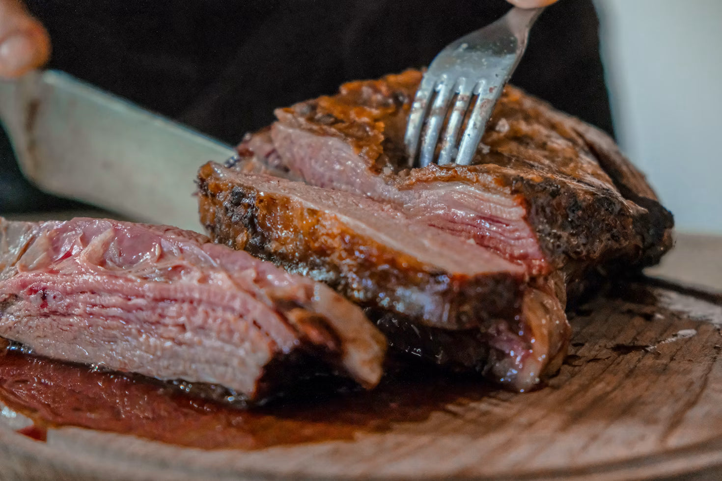 Close-up of sliced grass-fed steak on a wooden board